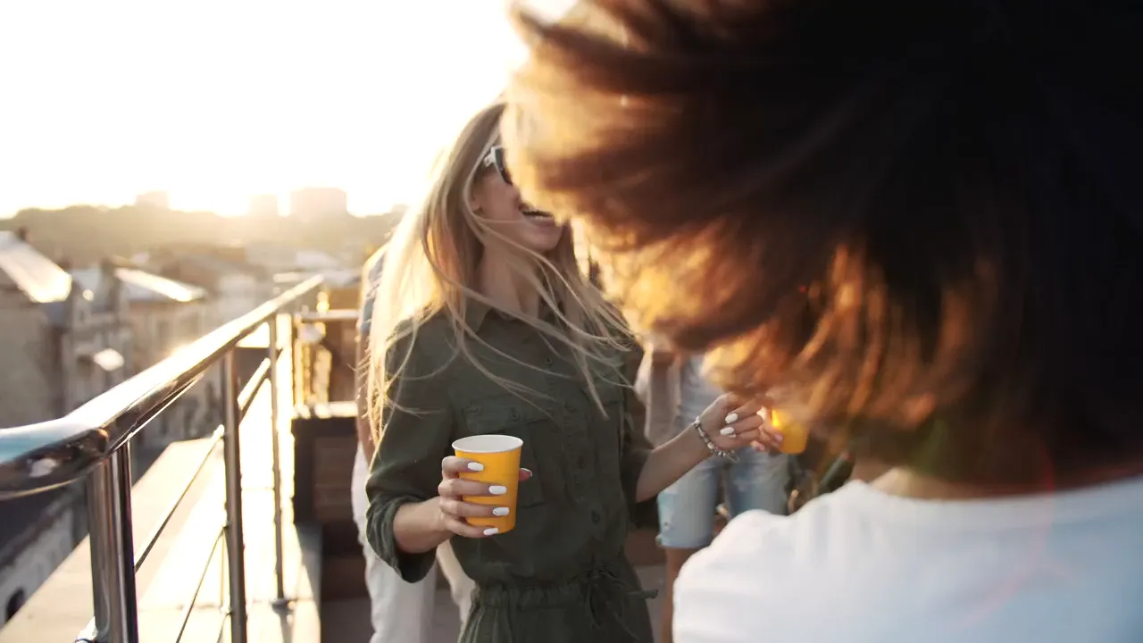 Friends dancing on a terrace at golden hour